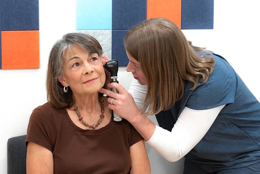 Dr. Marotto looking into a patient's ear with an otoscope